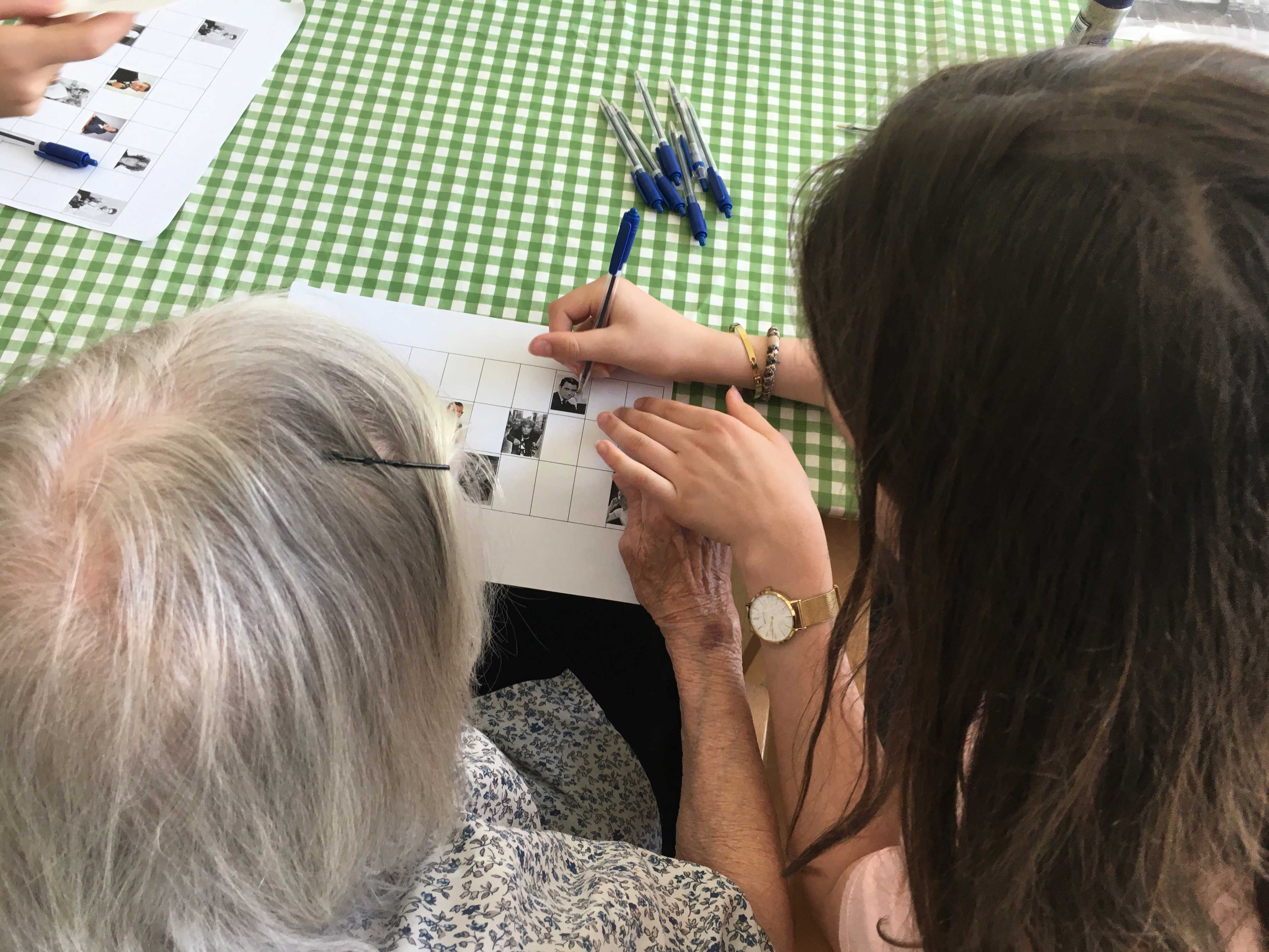 En medarbejder hjælper en beboer med at spille banko.